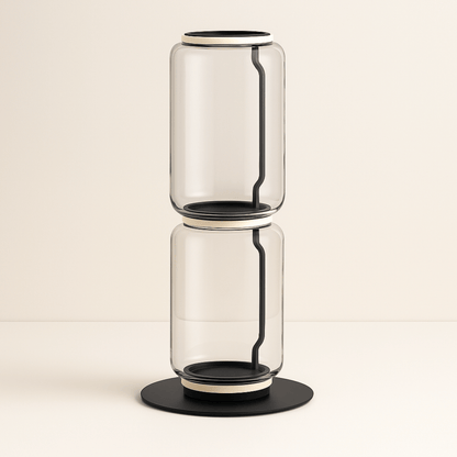 Clear glass vase with black accents on a beige background