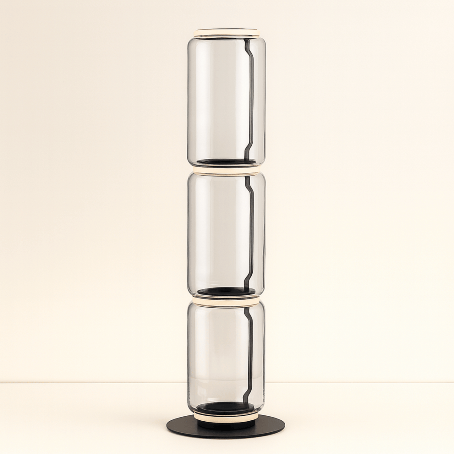Stack of three clear glass vases on a beige background