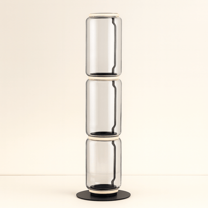 Stack of three clear glass vases on a beige background