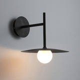 Modern wall-mounted light fixture with a single bulb on a gray background