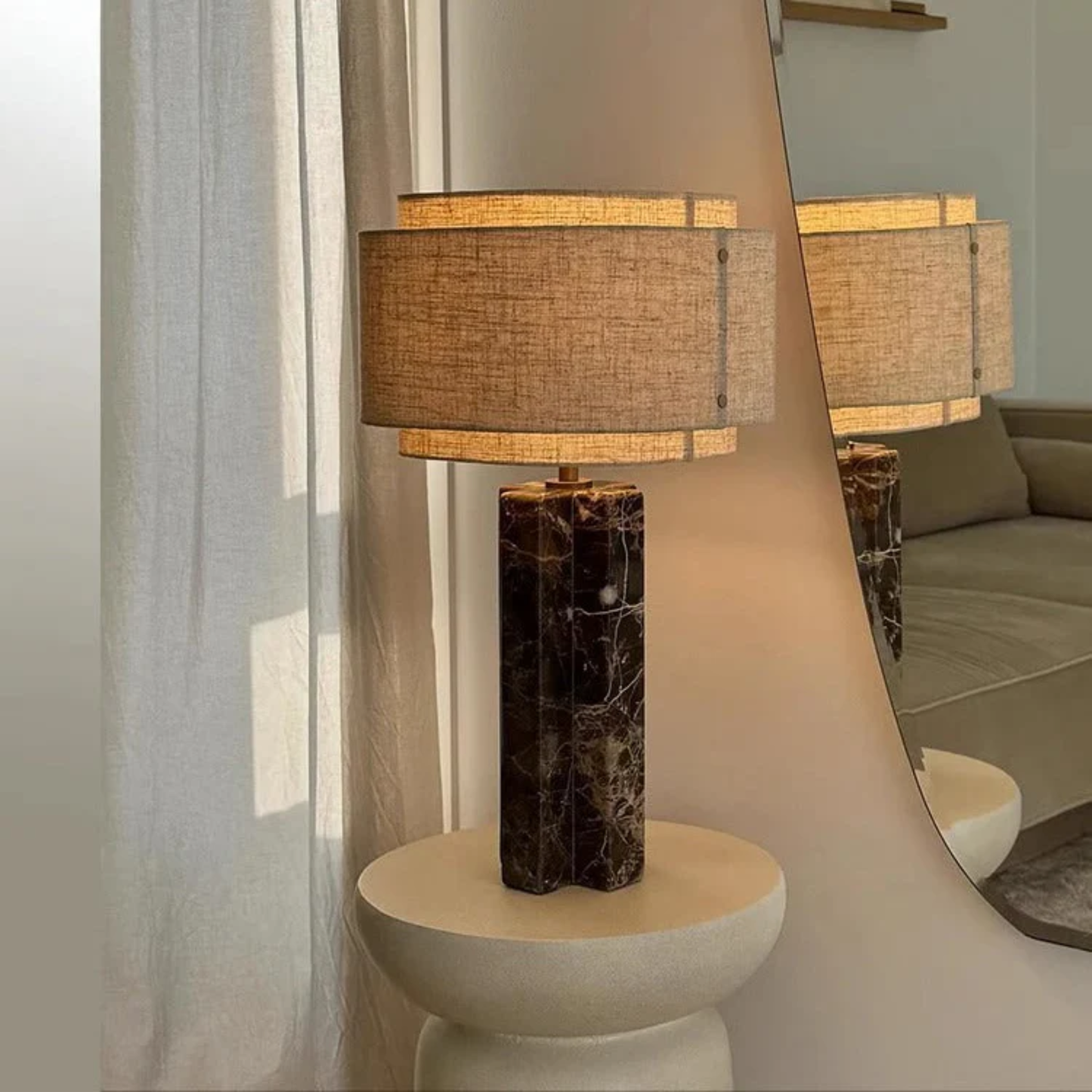 Decorative table lamp with a textured base and lampshade in a room setting.