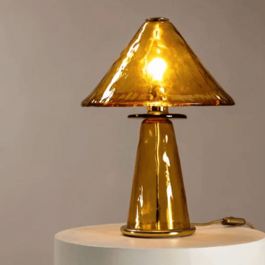 Gold table lamp with a textured shade on a neutral background