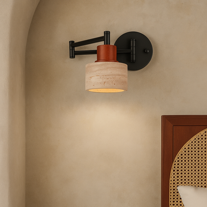 Wall-mounted light fixture with a beige lampshade and black metal arm on a beige wall.