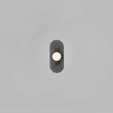 vertical sconce with three dome lights attached to brass bar on textured black plate