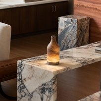 Marble table with a lit bottle in a modern living room setting