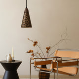 Modern interior with a brown chair, black table, and decorative lamp against a beige wall.