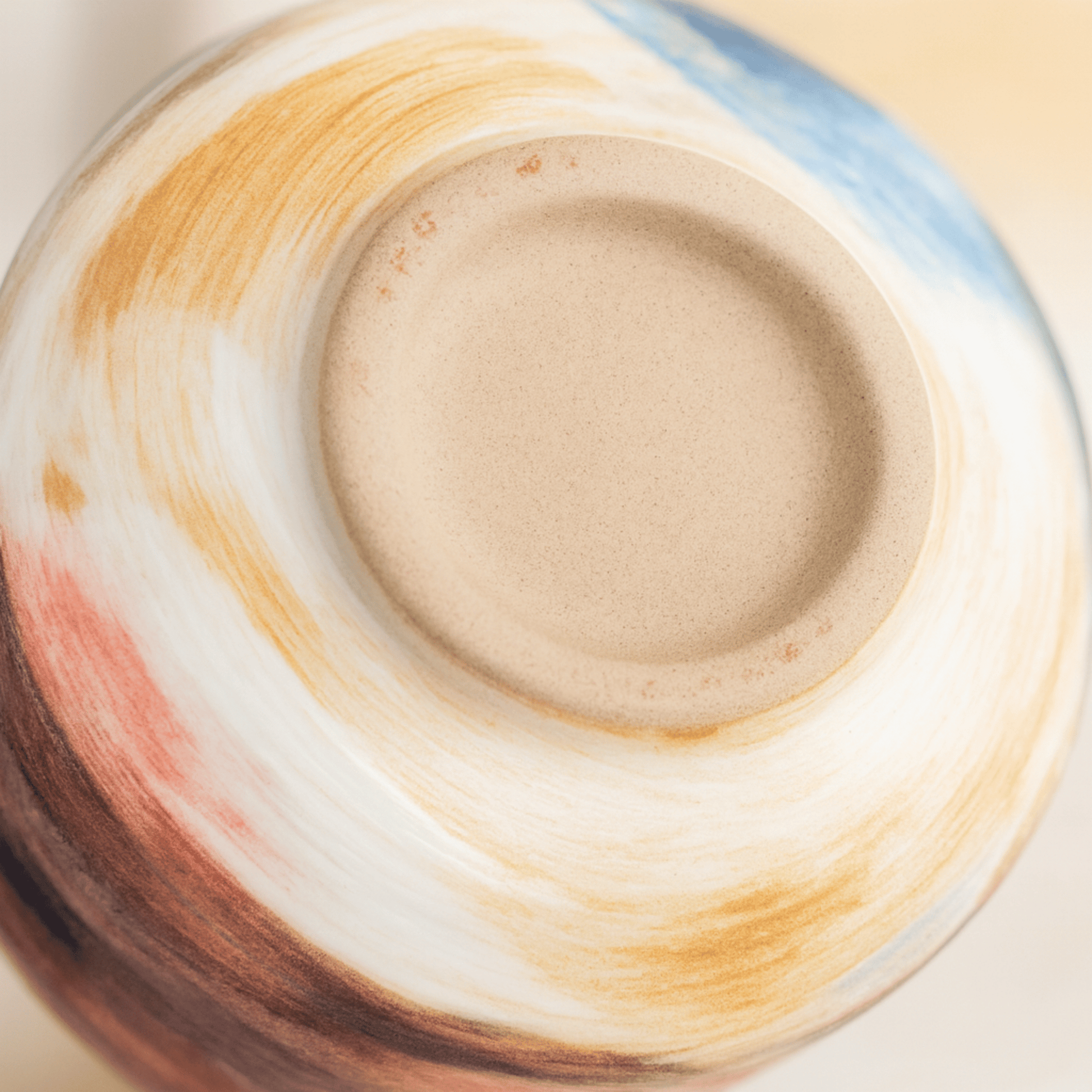Close-up of a ceramic bowl with multicolored glaze patterns
