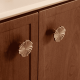 Wooden cabinet with decorative knobs on a neutral background