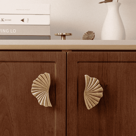 Wooden cabinet with shell-shaped handles on a neutral background