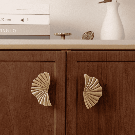 Wooden cabinet with shell-shaped handles on a neutral background