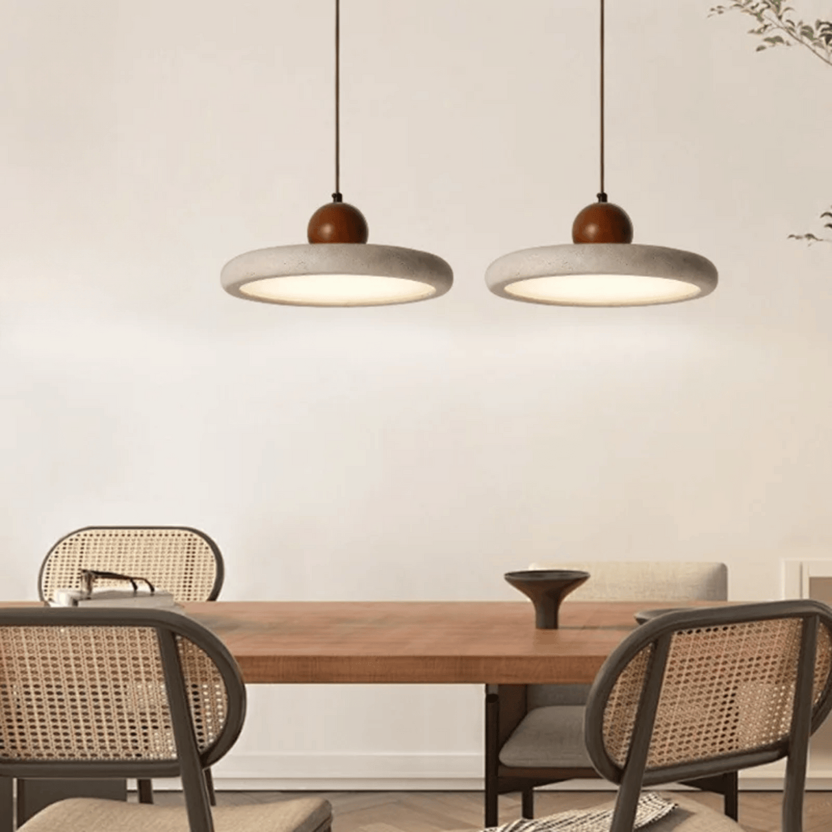 Dining area with wooden table and chairs under two pendant lights.