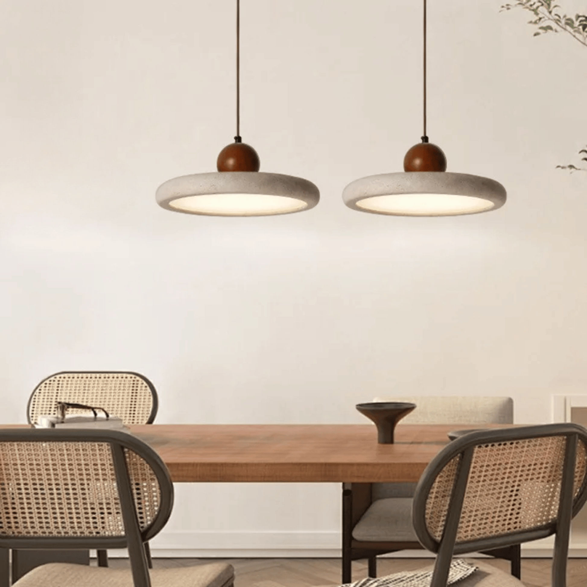 Dining area with wooden table and chairs under two pendant lights.