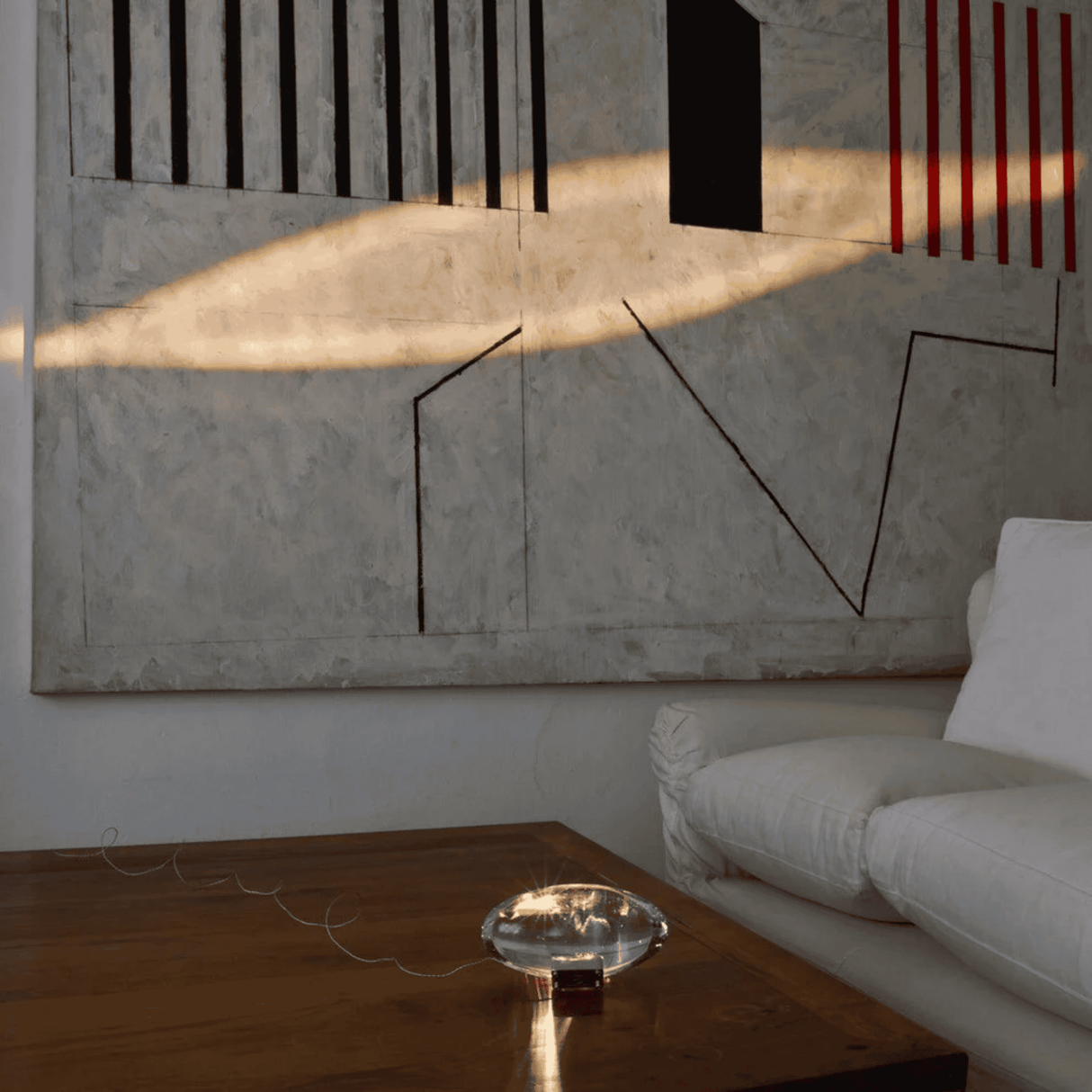Modern living room with abstract art on the wall and a white sofa.