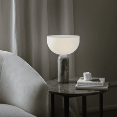 Table lamp on a side table next to a sofa with a neutral color scheme