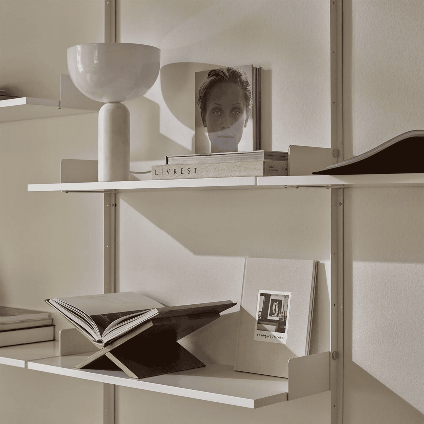 Shelving unit with books and decorative items against a neutral wall