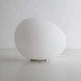 White spherical lamp on a light gray surface with a white background