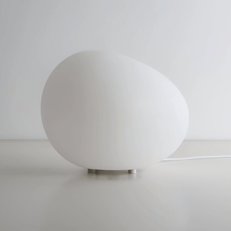 White spherical lamp on a light gray surface with a white background