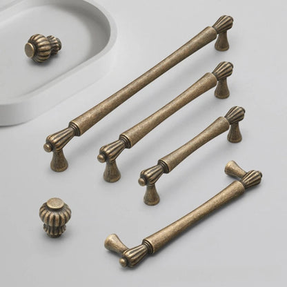Set of bronze cabinet handles and knobs on a light gray background