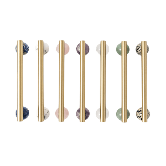 Set of gold cabinet handles with marble knobs on a white background
