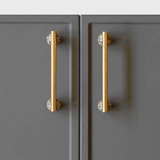 Gold cabinet handles on gray doors