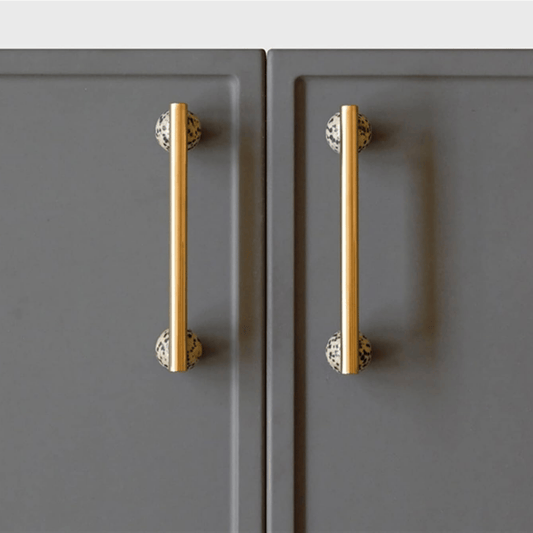 Gold cabinet handles on gray doors