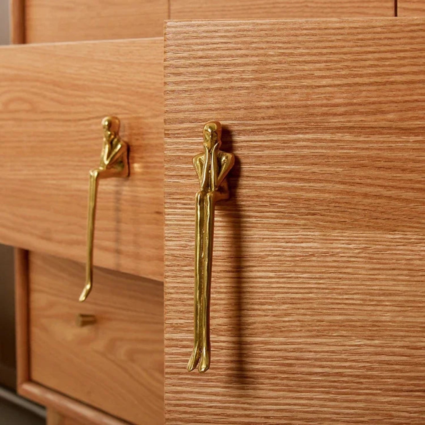 Wooden cabinet with gold humanoid handles