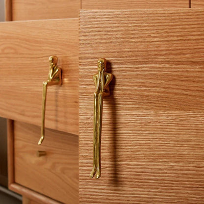Wooden cabinet with gold humanoid handles