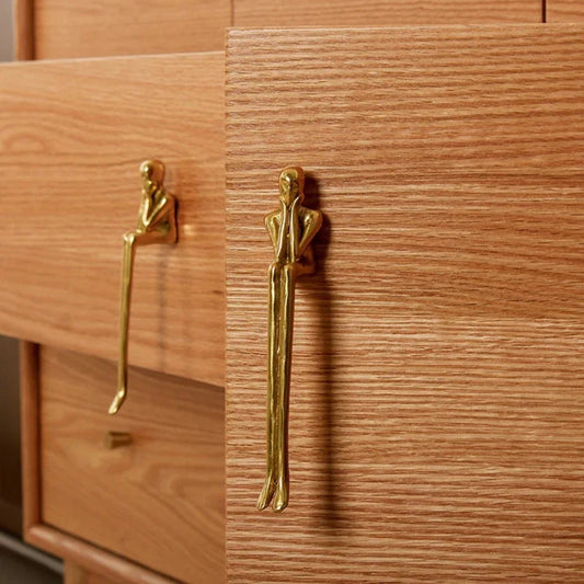 Wooden cabinet with gold humanoid handles
