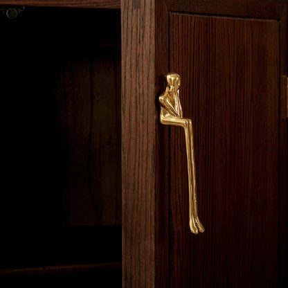 Wooden cabinet with gold humanoid handles