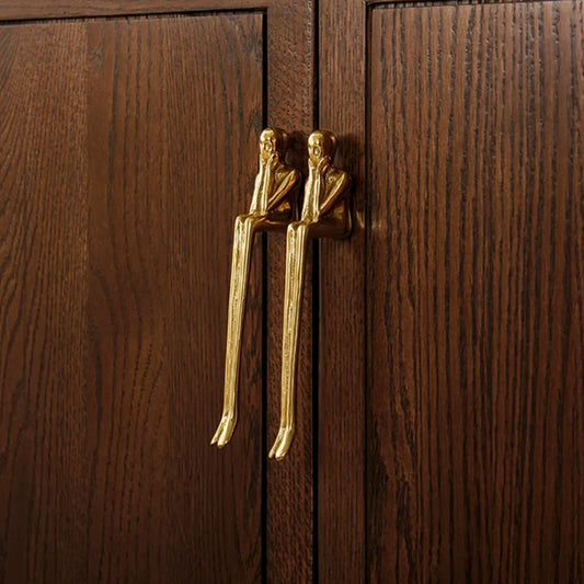 Wooden cabinet with gold humanoid handles