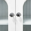 Decorative cabinet with shell-shaped handles against a white background