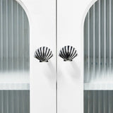 Decorative cabinet with shell-shaped handles against a white background
