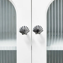 Decorative cabinet with shell-shaped handles against a white background