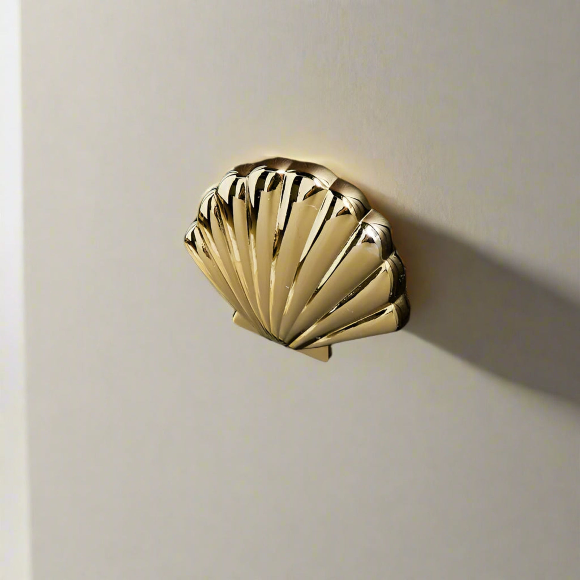 Gold shell-shaped door handle on a wooden door