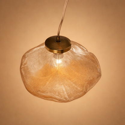 Amber glass pendant light against a beige background