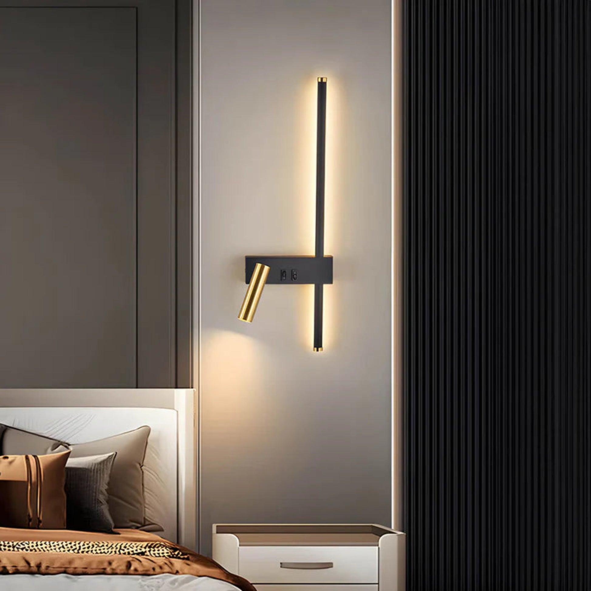 Modern wall sconce on a bedroom wall with a bed and headboard in the background.