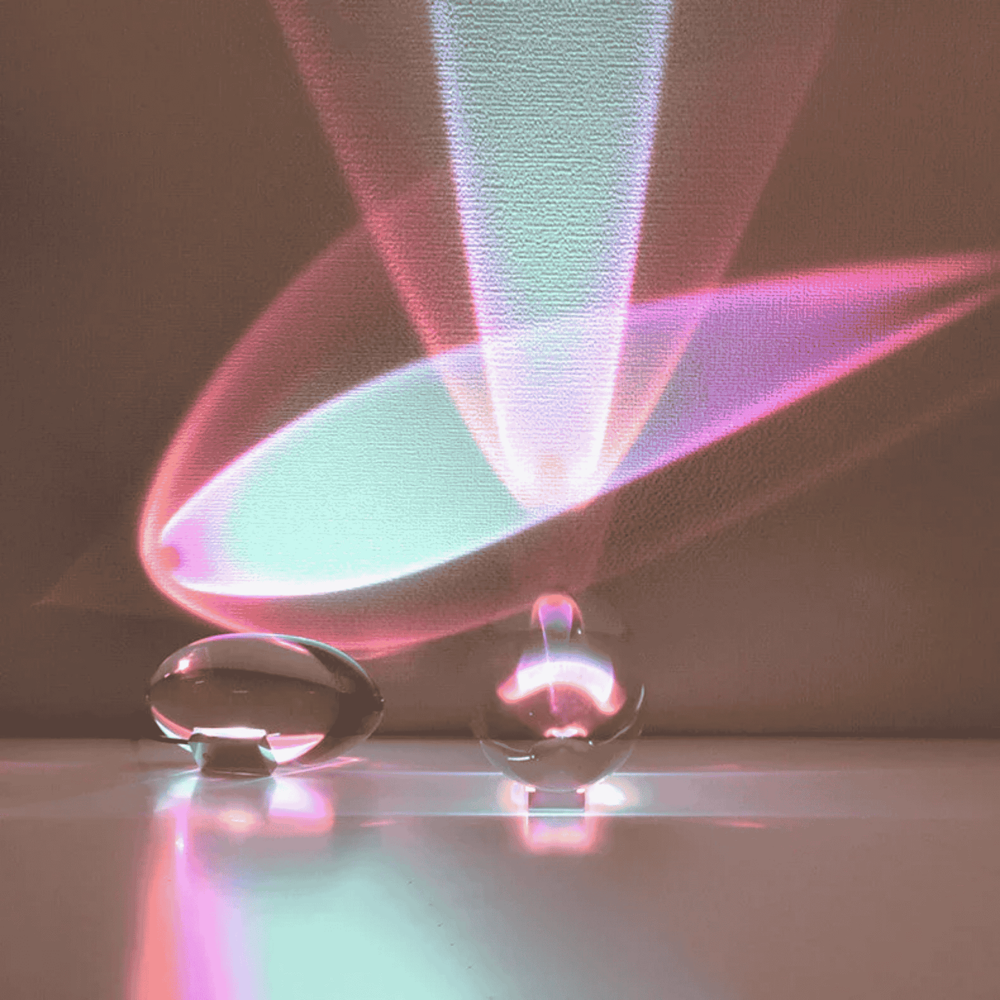 Two clear glass table lamp with colorful light patterns on a dark background