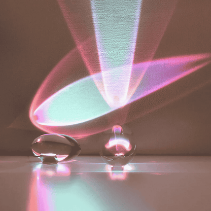Two clear glass table lamp with colorful light patterns on a dark background