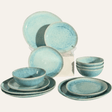 Set of blue ceramic dinnerware including plates and bowls on a white background