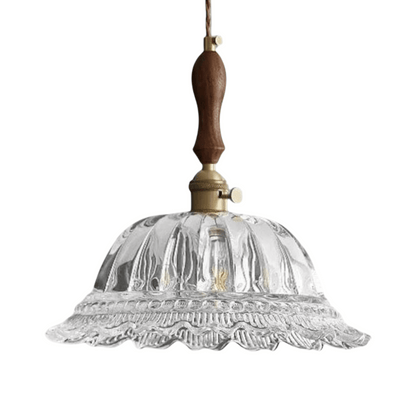 Clear glass pendant light with wooden and brass accents on a white background