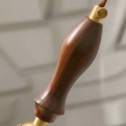 Wooden handle with gold accents on a gray background