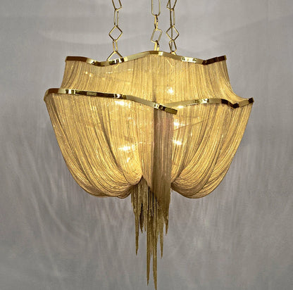 Gold chandelier with textured shade on a gray background
