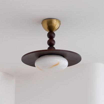 Ceiling light fixture with brass and wood design on a white ceiling