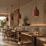 A row of terracotta-colored ceramic pendant lights hanging over a modern restaurant dining area with wooden chairs, tables, and warm ambient lighting.