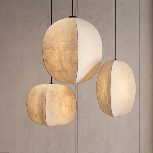Three spherical pendant lights with beige and white fabric shades on a neutral background