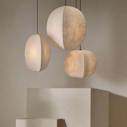 Three spherical pendant lights hanging against a neutral wall.