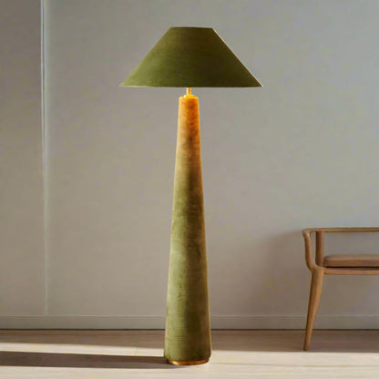 Green floor lamp with a textured base and cone-shaped shade on a wooden floor.