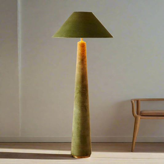 Green floor lamp with a textured base and cone-shaped shade on a wooden floor.