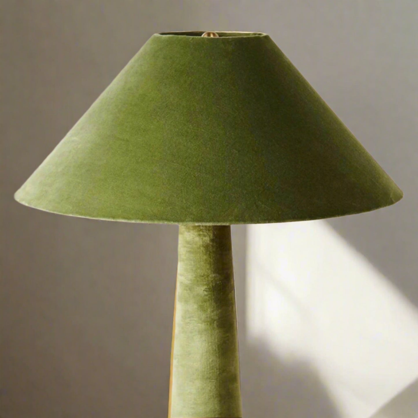 Green lamp with a conical shade on a light background

