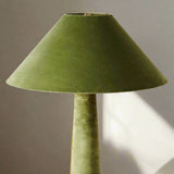 Green lamp with a conical shade on a light background

